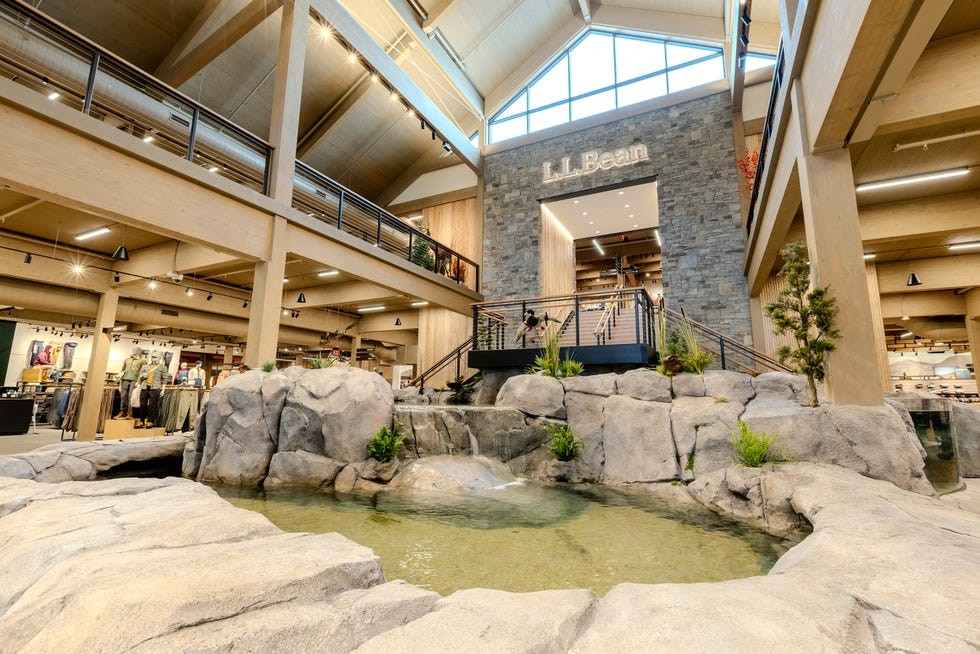 Interior view of L.L. Bean store featuring a rock formation and a small pond with a waterfall.