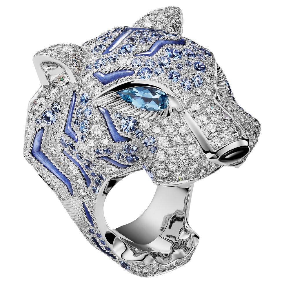 Silver ring shaped like a tiger's head, embellished with blue and clear gemstones.