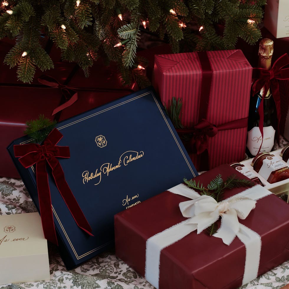 Variety of elegantly wrapped holiday gifts and a festive advent calendar under a Christmas tree.