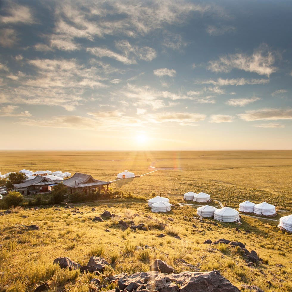 Nomadic Expedtions' Three Camel Lodge Aerial view of yurt accommodations in a vast, open landscape during sunset.