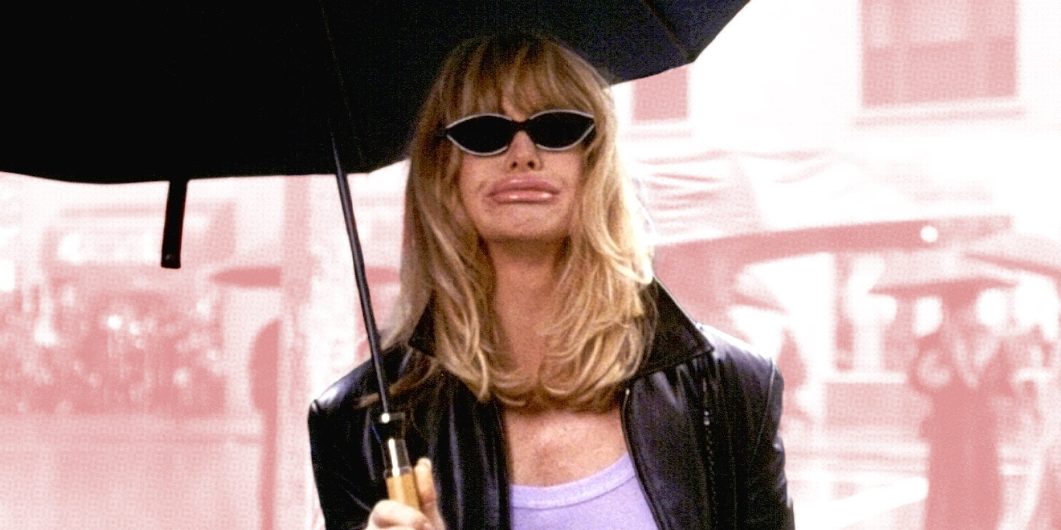 Person with blonde hair wearing sunglasses and holding an umbrella, dressed in a leather jacket.