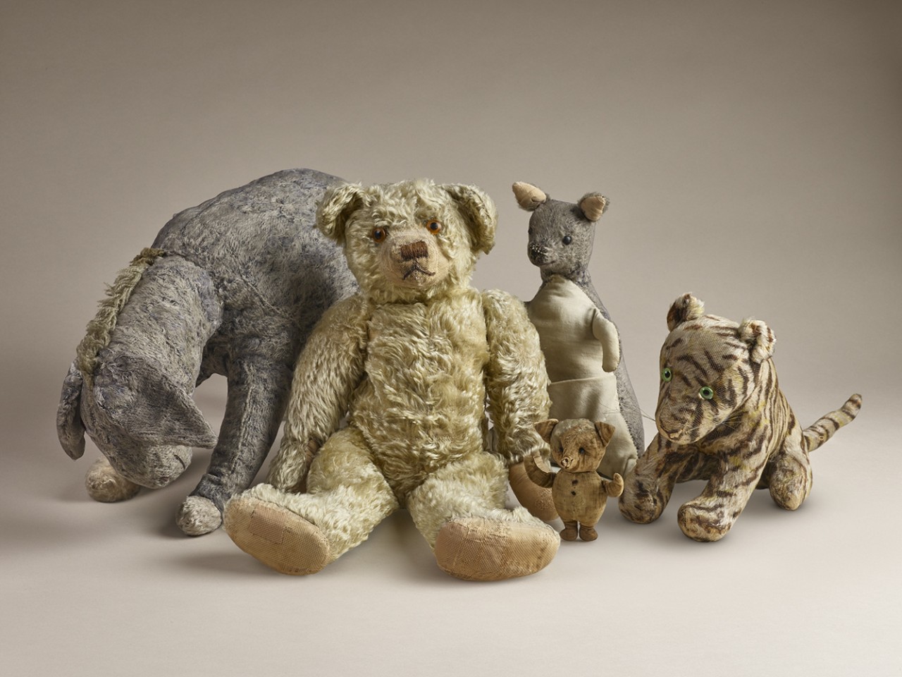 Four unique stuffed animals, including a bear, tiger, mouse, and rabbit, displayed against a neutral background.