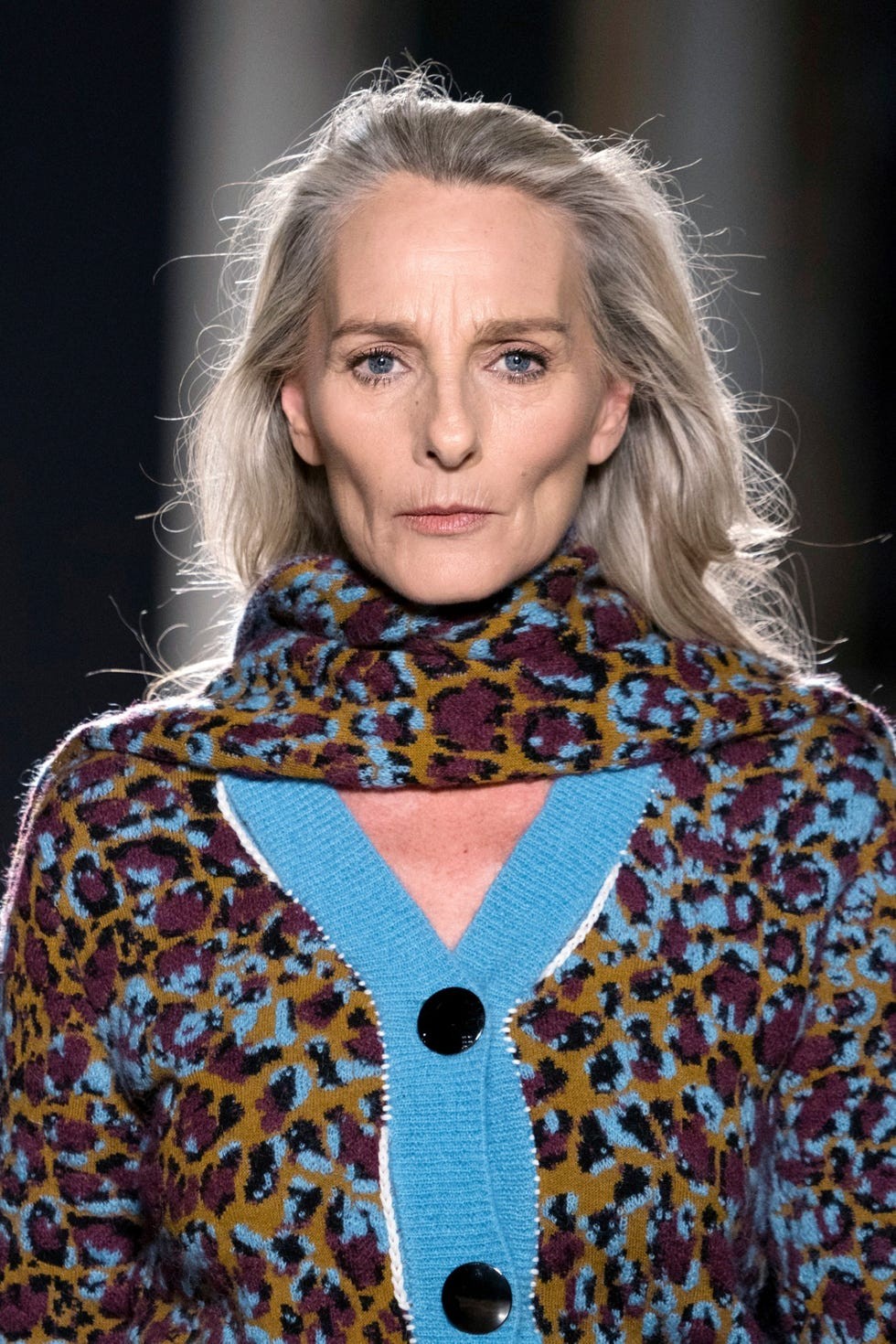 model wearing leopard print sweater with turquoise accents on runway.