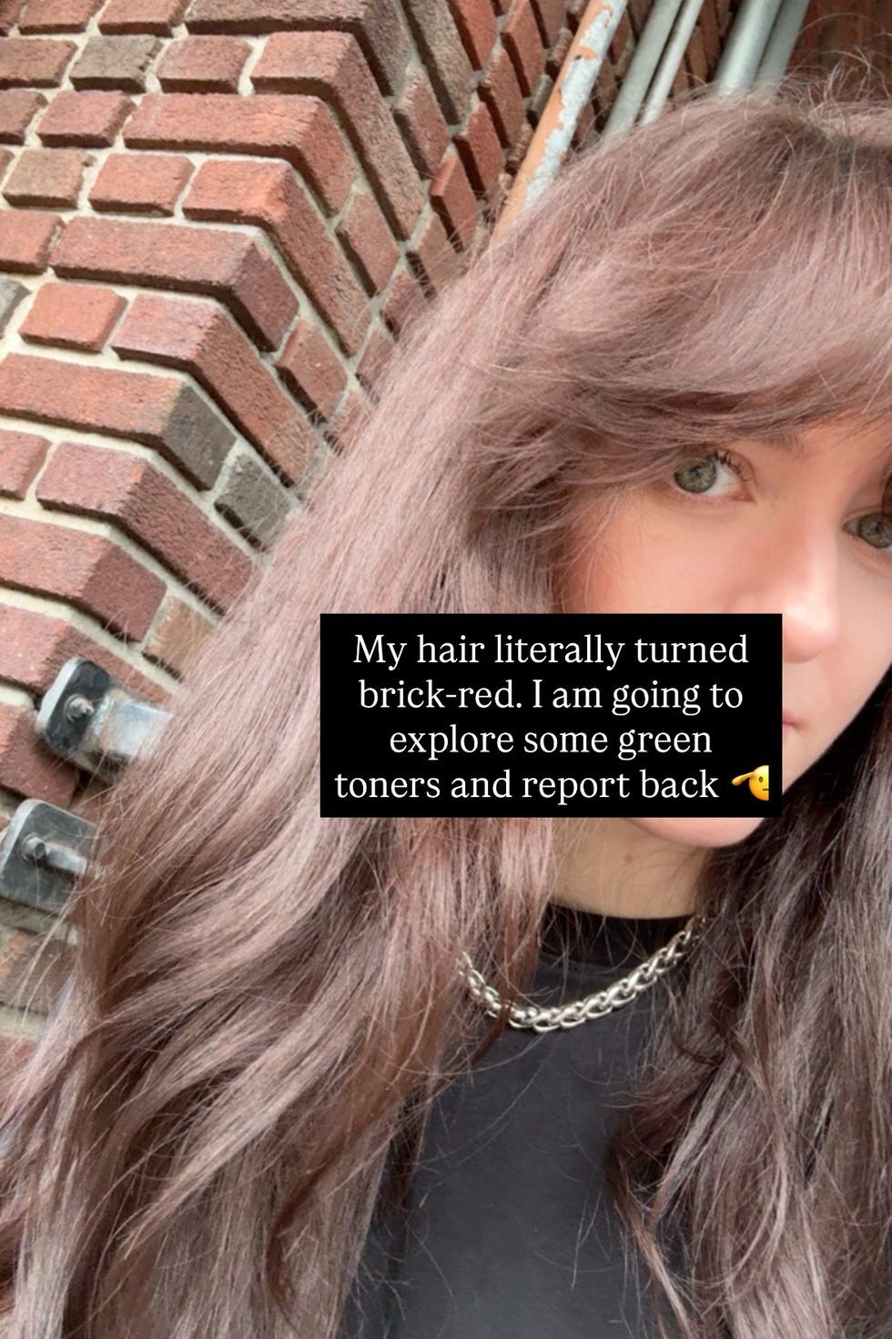 Close-up of a person with long hair, wearing a chain necklace, next to a brick wall, discussing hair color changes.
