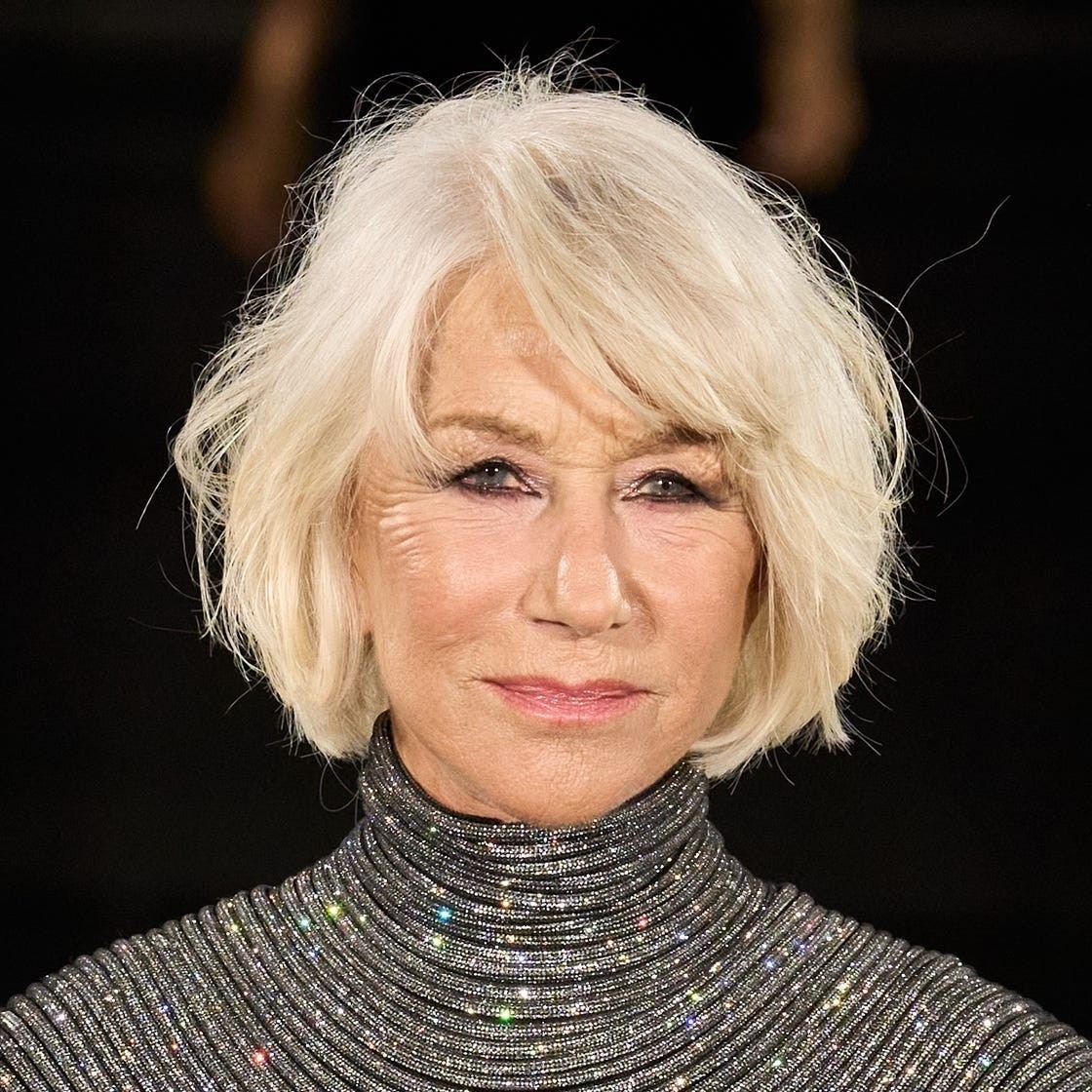 A mature woman with short, styled blonde hair wearing a sparkly turtleneck sweater, gazing confidently at the camera.