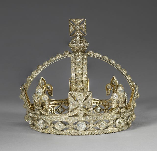 A decorative crown adorned with numerous sparkling jewels, featuring intricate floral motifs.