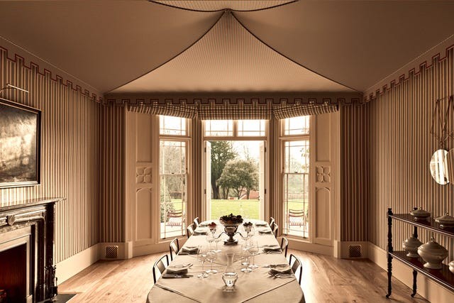 Elegant dining room with a long table, vintage decor, and large windows overlooking a garden.