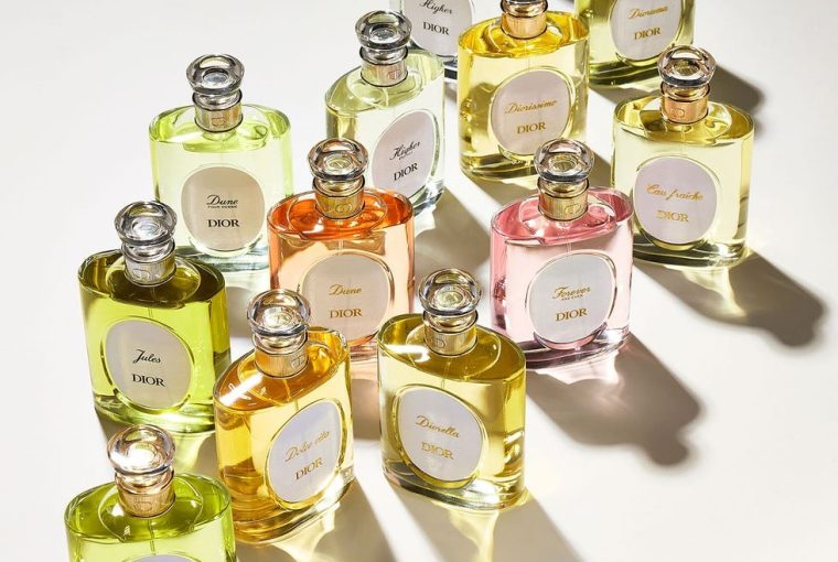 Collection of various Dior perfume bottles in different colors and shapes arranged artistically on a light background.