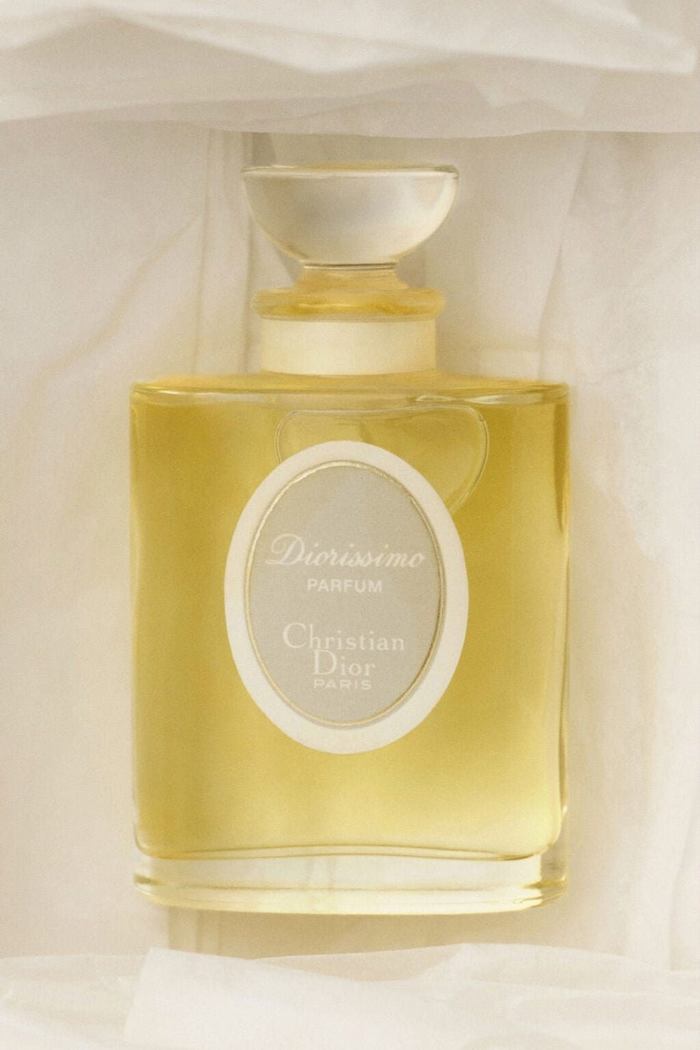 Diorissimo parfum bottle by Christian Dior, featuring a golden liquid and elegant label.