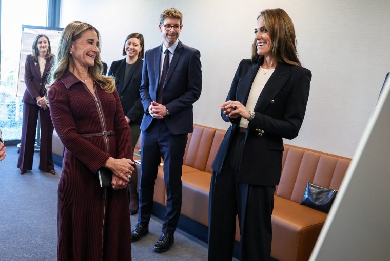 A group of people engaged in a conversation in a modern office setting.