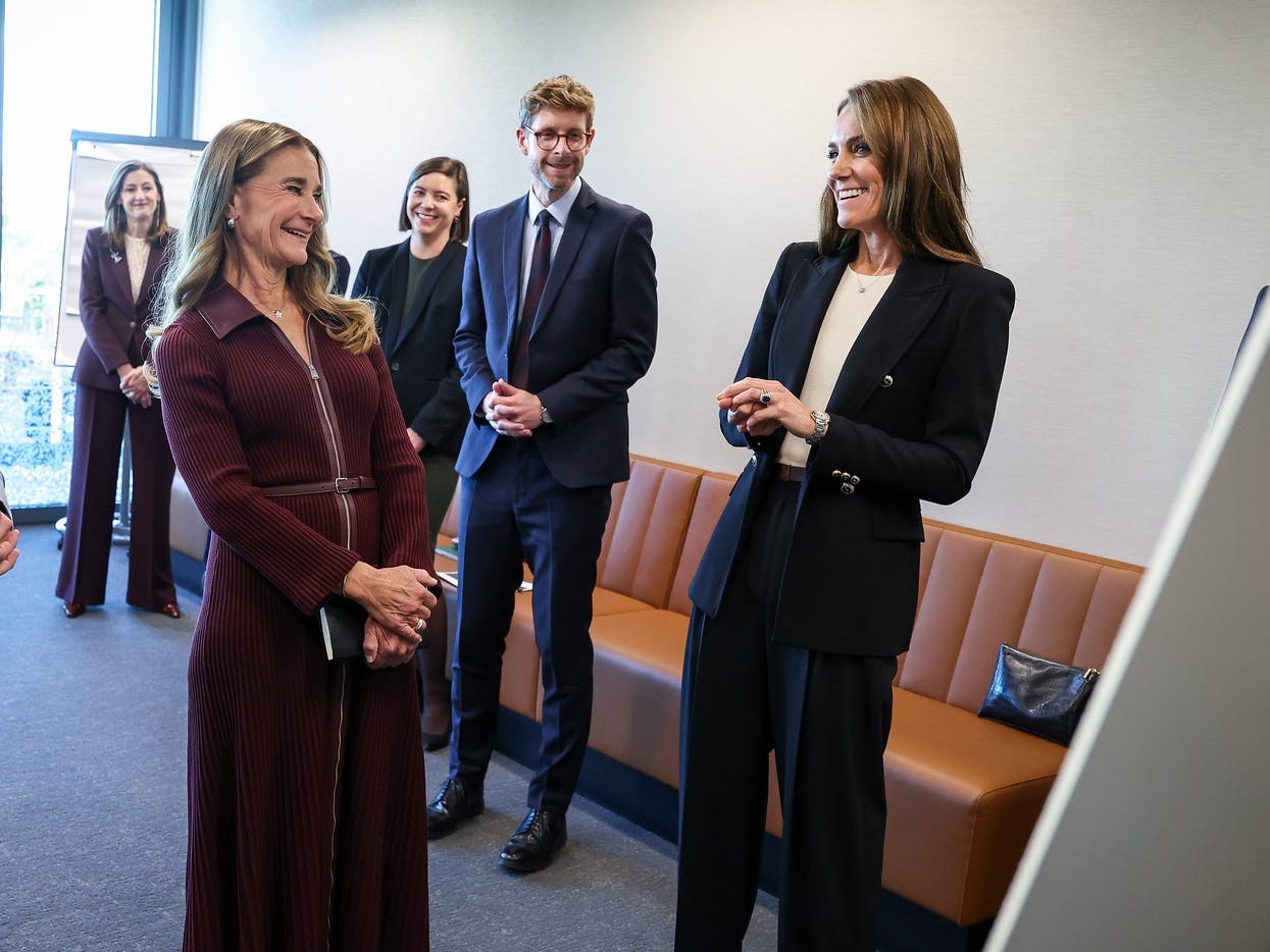 A group of people engaged in a conversation in a modern office setting.