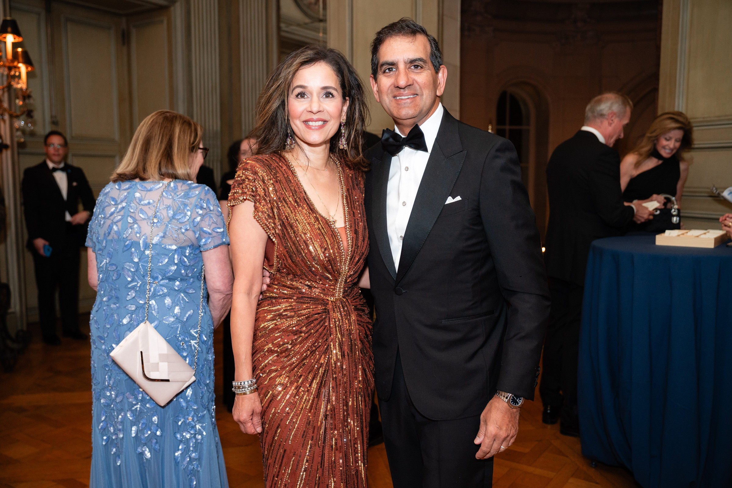 A couple poses together at a formal event, dressed in elegant evening attire.