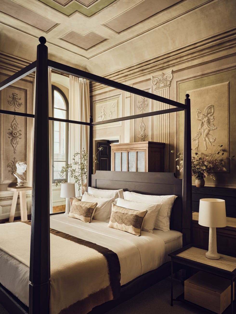 Luxurious bedroom featuring a four-poster bed, decorative walls, and elegant furnishings.