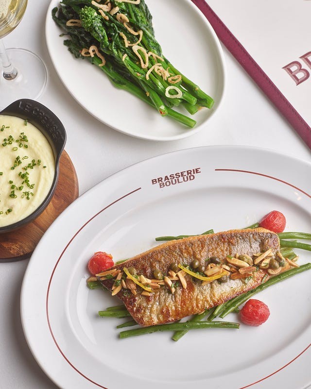 Grilled fish with green beans, cherry tomatoes, and slivered almonds, served with sautéed greens and creamy mashed potatoes.