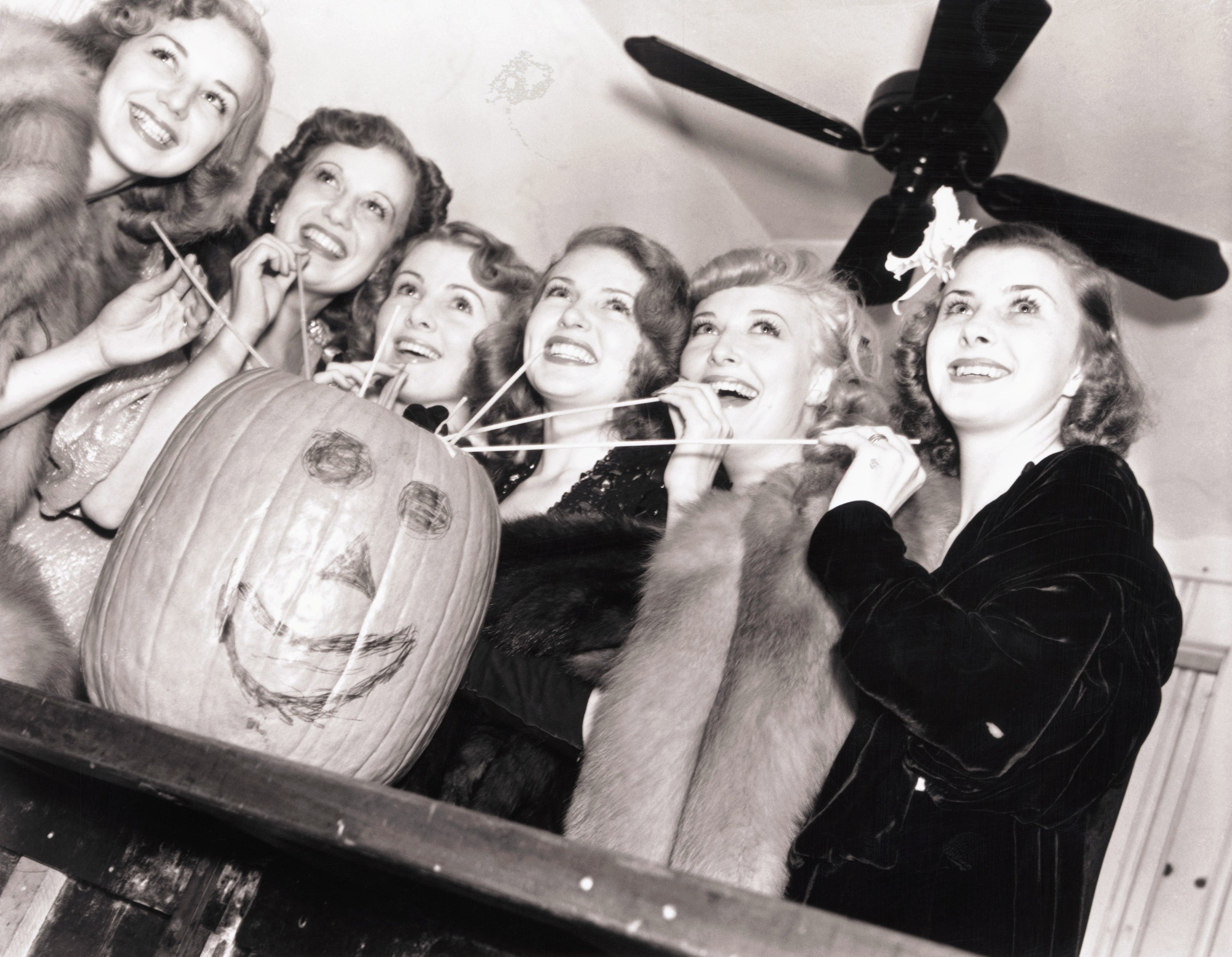 lana turner and friends drinking from a pumpkin