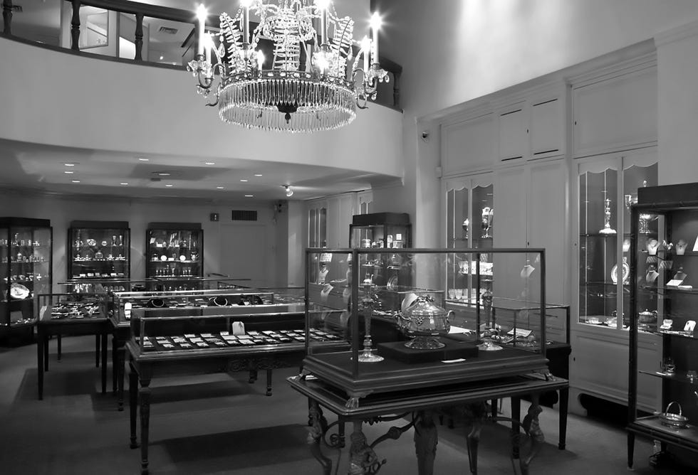 Interior view of a museum gallery showcasing display cases with various artifacts and a chandelier above.