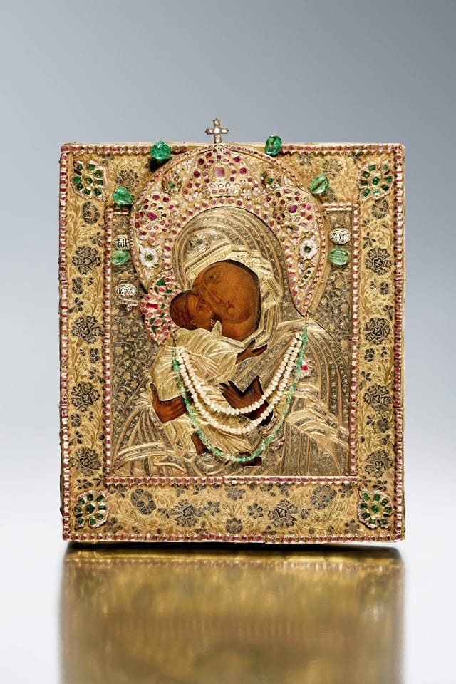 Gold and jeweled icon depicting a mother and child, richly detailed with intricate patterns and embellishments.