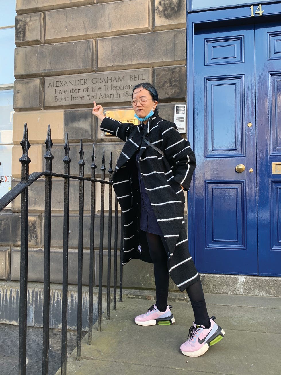 Person pointing at a plaque commemorating Alexander Graham Bell at his birthplace in Edinburgh, Scotland.