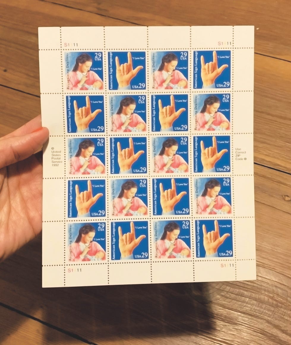 Sheet of American Sign Language "I Love You" stamps, featuring a woman signing, with 20 stamps on display.